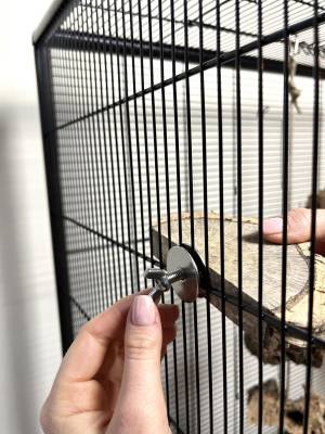 Korkbrettchen am Käfig befestigen Flügelmutter von Hand festschrauben
